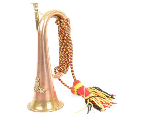 A 20th century brass and copper bugle with applied brass military plaque.