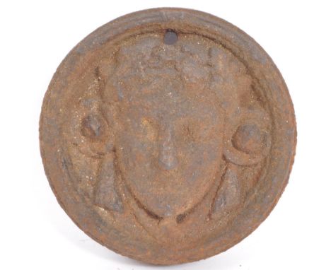 A 19th century cast iron architectural salvage roundel wall plaque with moulded classical style face to centre. Measures 11cm