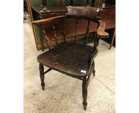 A set of eight early 20th Century stained beech and elm smoker's bow chairs with spindle backs and saddle seats, raised on tu