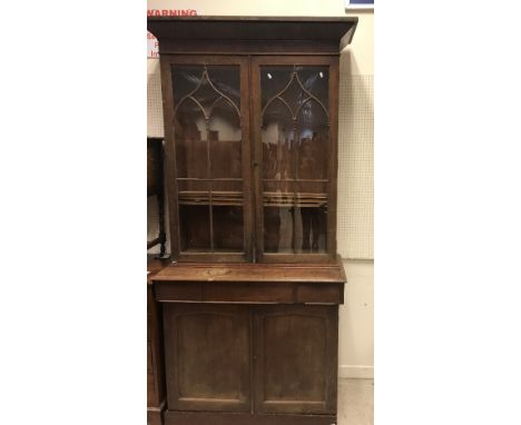 A 19th Century mahogany bookcase cabinet, the associated top with canted cornice over two Gothic arch style glazed doors encl