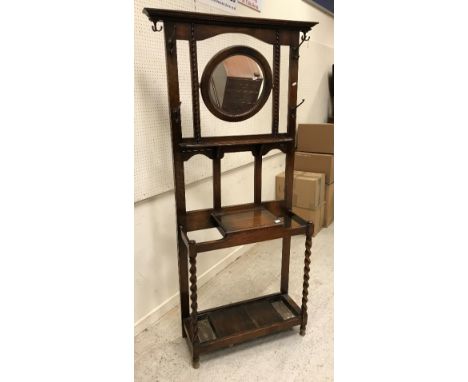 An early 20th Century oak hall stand with swivel mirror and glove box flanked by two stick stands on barley twist supports 76