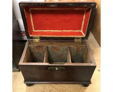 A George III mahogany sarcophagus shaped tea caddy with brass swan neck handle raised on turned cup and cover supports (canis