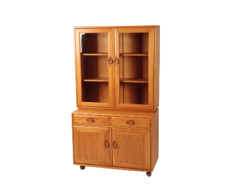 ERCOL: A "WINDSOR" ASH DISPLAY CABINET, two glazed doors fitted with two single shelves, below two drawers and two cupboard d