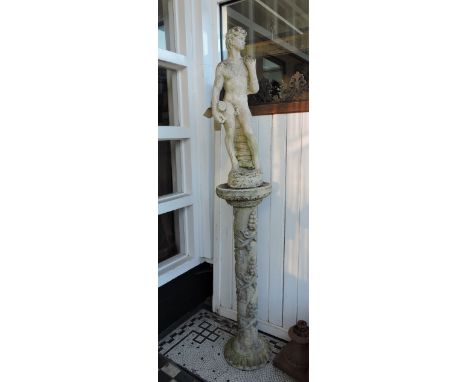 A cast reconstituted stone garden statue of David on a cast bacchihc pedestal, H. 198cm.