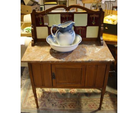 A late Victorian marble top washstand, the raised back inset Art Nouveau style ceramic tiles, together with a ceramic jug and
