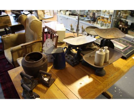 A collection of enamel and cast iron kitchenalia including soda jar, flat irons, and scales.