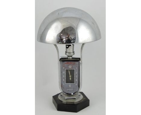 A 1930s Jaeger Le Coultre Luxhora chrome table lamp with domed shade over a twin dial, glazed timepiece on hexagonal base, H.