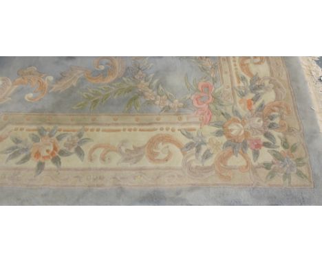 A Chinese pale blue ground carpet with wide floral border approx. 12ft x 8ft.