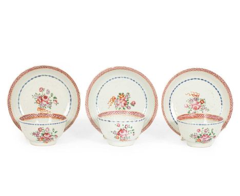 A set of three Chinese famille rose tea bowls and saucers, Qianlong, decorated with sprays of flowers with bands of blue enam