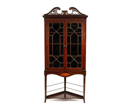 A George III Irish inlaid mahogany corner cabinet on later stand, the upper part with two glazed doors enclosing three adjust