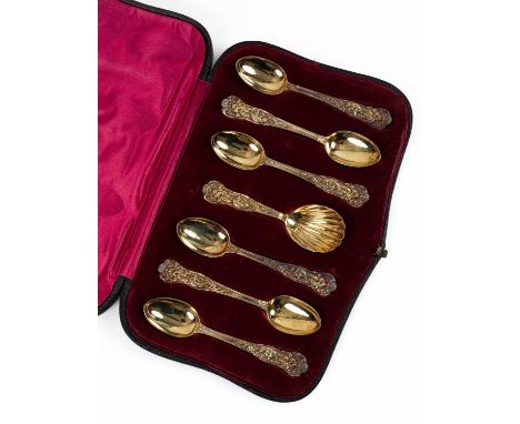 A set of six Victorian silver gilt teaspoons and a caddy spoon, H J Lias &amp; Son, London 1876, the handles elaborately cast