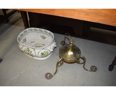 A reproduction footbath and brass ceiling light fitting