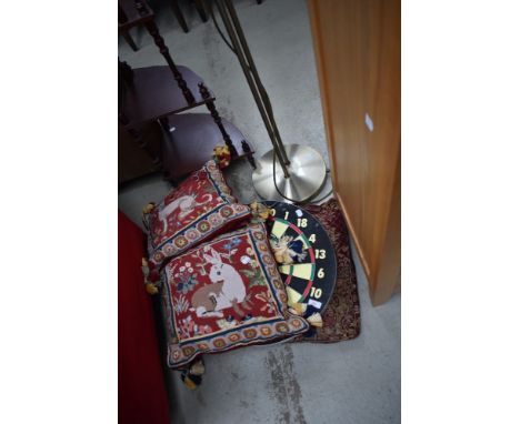 A dartboard and selection of cushions including tapestry style