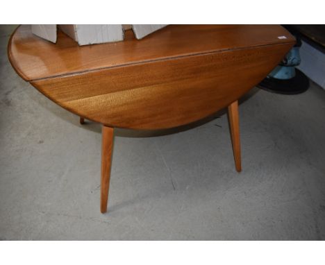 An Ercol style drop leaf kitchen table having splay legs