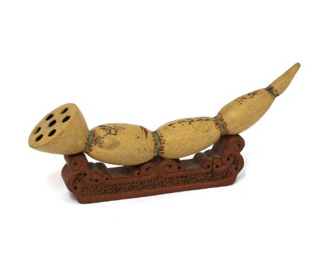 A Chinese Yixing zisha brush rest, in the shape of a lotus root and seed pod on a shaped stand with scrolls, incised with an 