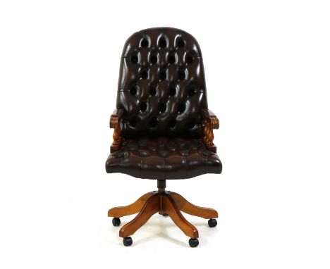 A button back leather office swivel chair, the arch back above reeded arms, each with turned baluster supports, raised on a s