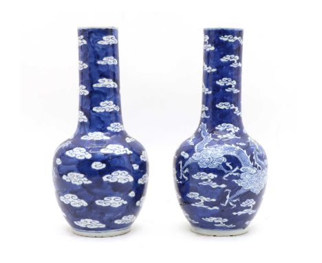 A pair of Chinese blue and white vases, c.1900, of ovoid form with a long cylindrical neck, painted with two dragons chasing 