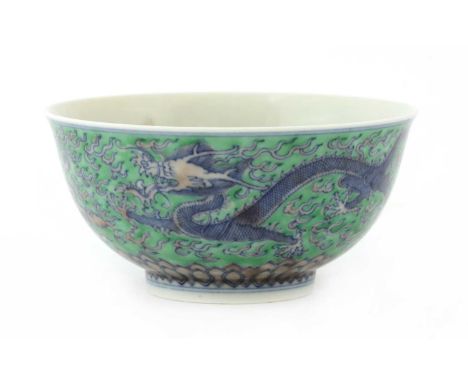 A Chinese green enamelled bowl, the rounded form on a circular foot rising to a slightly flared mouth, painted with dragons c