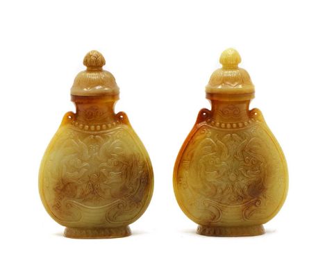 A pair of Chinese jade vases and covers, in the shape of a leather pouch-form flask with drilled holes to the top for suspens