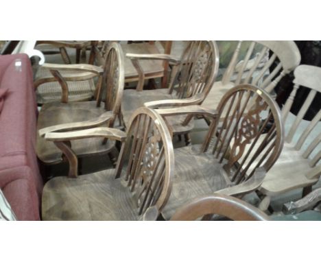 A set of four elm seated stick and wheel back carver chairs