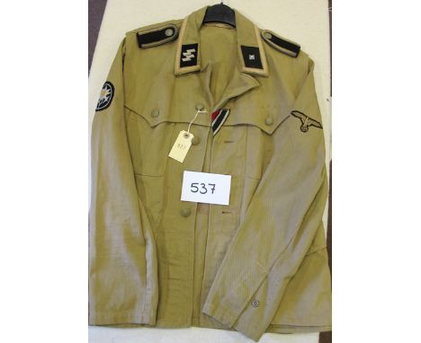 A German Waffen SS “Sahariana” style summer tunic,  of sand coloured heavy cotton fabric, with grey cotton SS runes collar pa