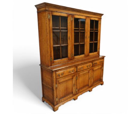 Georgian style oak dresser, with moulded cornice above three astragal glazed doors enclosing shelves, over a base fitted with