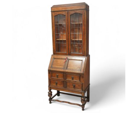 Early 20th century oak bureau bookcase, the upper section with a pair of leaded glass doors enclosing adjustable shelves, ove