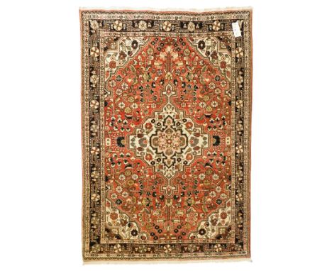 Persian Heriz-style rug, bold geometric octagonal medallion, rich red field with ivory spandrels, dark navy border, rosettes 