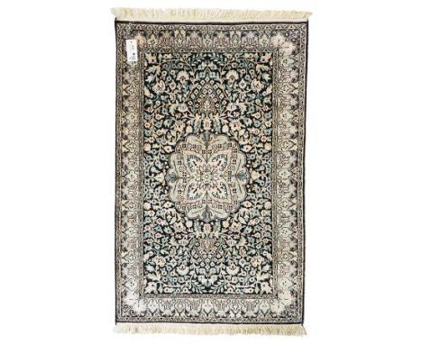 Persian style rug, central floral medallion surrounded by intricate palmetters, vines and rosettes, navy blue ground with ivo