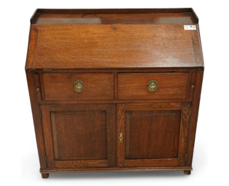 George III oak bureau, fall front enclosing fitted interior, two drawers over double panelled cupboard, on bracket feetDimens