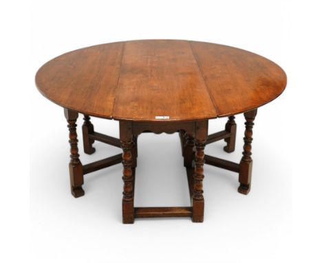 Georgian design oak drop-leaf dining table, oval drop-leaf over gate-leg action base, on turned supports united by stretchers