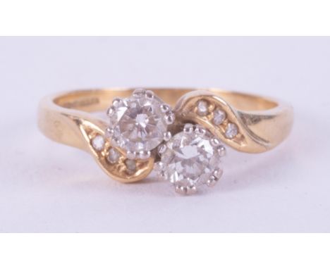 An 18ct yellow gold crossover style ring set with two round brilliant cut diamonds, approximate total weight 0.42 carats and 