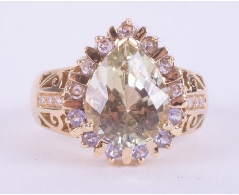 An 18ct yellow gold ornate style ring set with a central pear cut green/yellow tone gemstone possibly a Chrysoberyl?, approx.