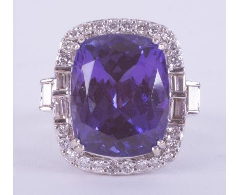 A fine and impressive 18ct white gold ring set with a fancy rectangular cushion cut 17 carat Tanzanite surrounded by a mixtur