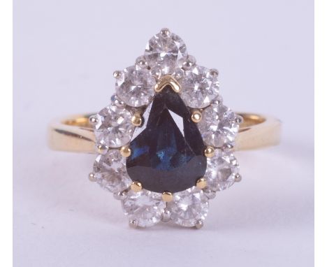 An 18ct yellow &amp; white gold pear shaped cluster ring set with a central pear shaped sapphire measuring approx. 0.82 carat