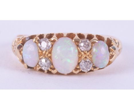 An 18ct yellow gold antique ring set with three oval cabochon cut opals interspaced by small round cut diamond, 3.25gm, size 