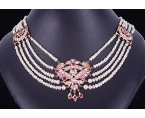 An ornate Asian designed necklace comprising of five rows of cream coloured natural shaped pearls which graduate in size to t