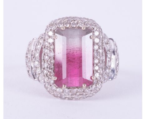 An 18ct white gold ornate style ring set with an emerald cut bi-colour tourmaline, approx. 4.10 carats, surrounded by small r