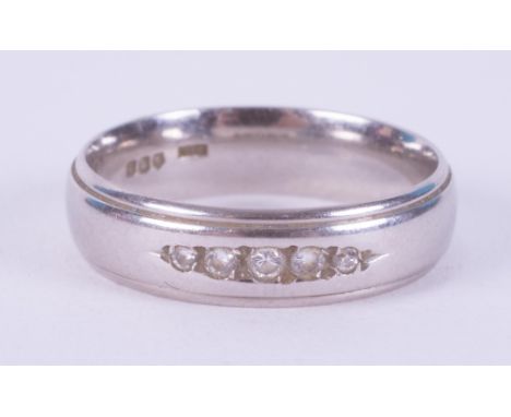A platinum band set with five small round brilliant cut diamonds, 5mm width, 6.48gm, size M 1/2. 9