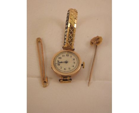 A 9 carat gold horseshoe tie pin, together with a further tie pin and a 9 carat gold cased wristwatch, the brushed dial set w