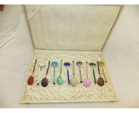 A cased set of twelve Norwegian silver gilt spoons with enamelled decoration to handle and bowl and with lotus shaped enamell