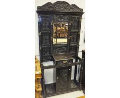 A Victorian Gothic Revival hall stand with coat hooks and stick stand flanking drawer and cupboard door
