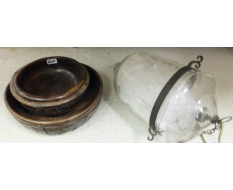 A modern cut glass hanging hurricane lamp and a set of three wooden carved African bowls