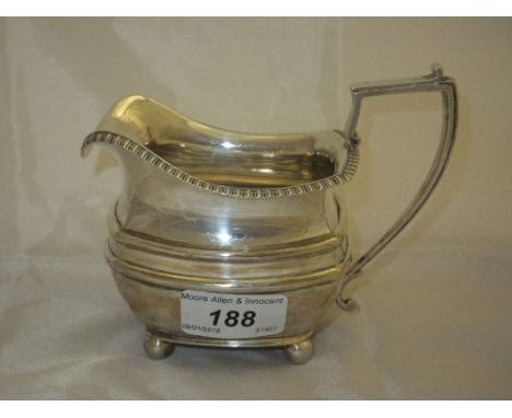 A Victorian silver cream jug of bellied squared form with gadrooned edge on four ball feet (by James Dixon & Son, Sheffield, 