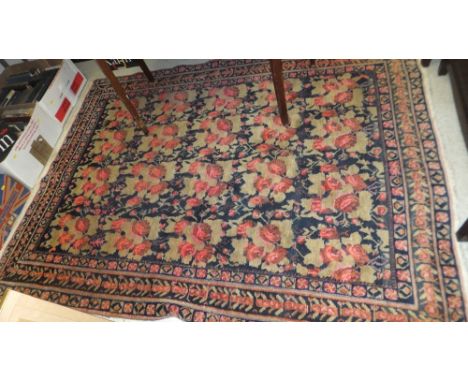 A Caucasian rug, the central panel set with repeating floral sprays on a dark blue ground within a stepped blue, green and pi