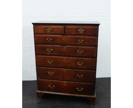 An oak chest of tall proportions, the rectangular top above two short drawers and five graduating long drawers,  on bracket f