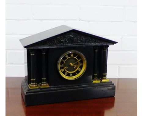 A black slate mantle clock with a carved classical frieze above the black enamel chapter ring with gilt Roman numerals, 30 x 