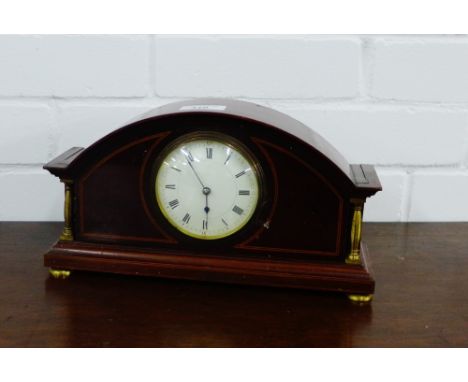 A mahogany and inlaid mantle clock, the enamel dial with Roman numerals flanked by gilt pilasters, on four brass feet, 30cm w