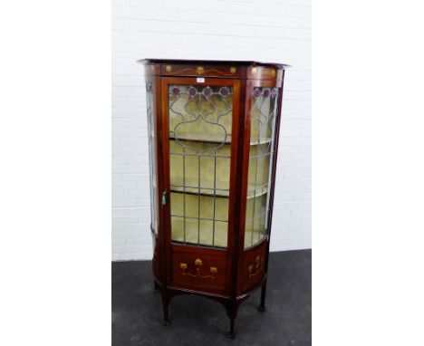 An Art Nouveau mahogany and inlaid vitrine with leaded panel glazed doors enclosing a fabric lined shelved interior, on squar
