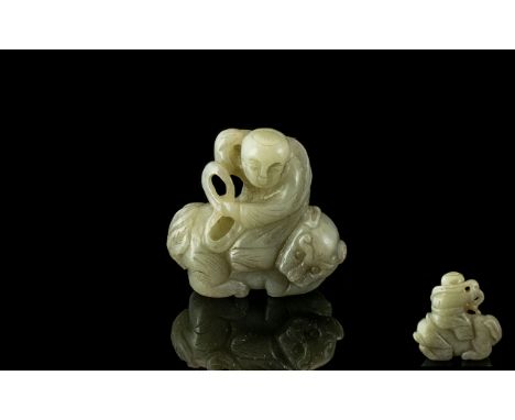 A Jade Carving of a Man riding a beast, measuring 2 inches high.